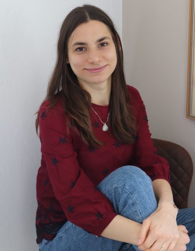 Alena, Webdesign mit Verkaufspsychologie, sitzt mit angezogenem bein