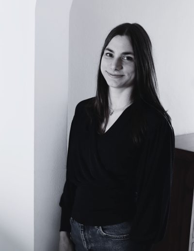 Webdesignerin Alena, an einer Wand lehnend