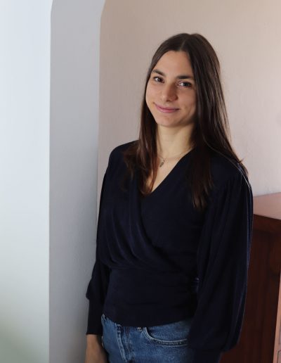 Webdesignerin Alena, an einer Wand lehnend